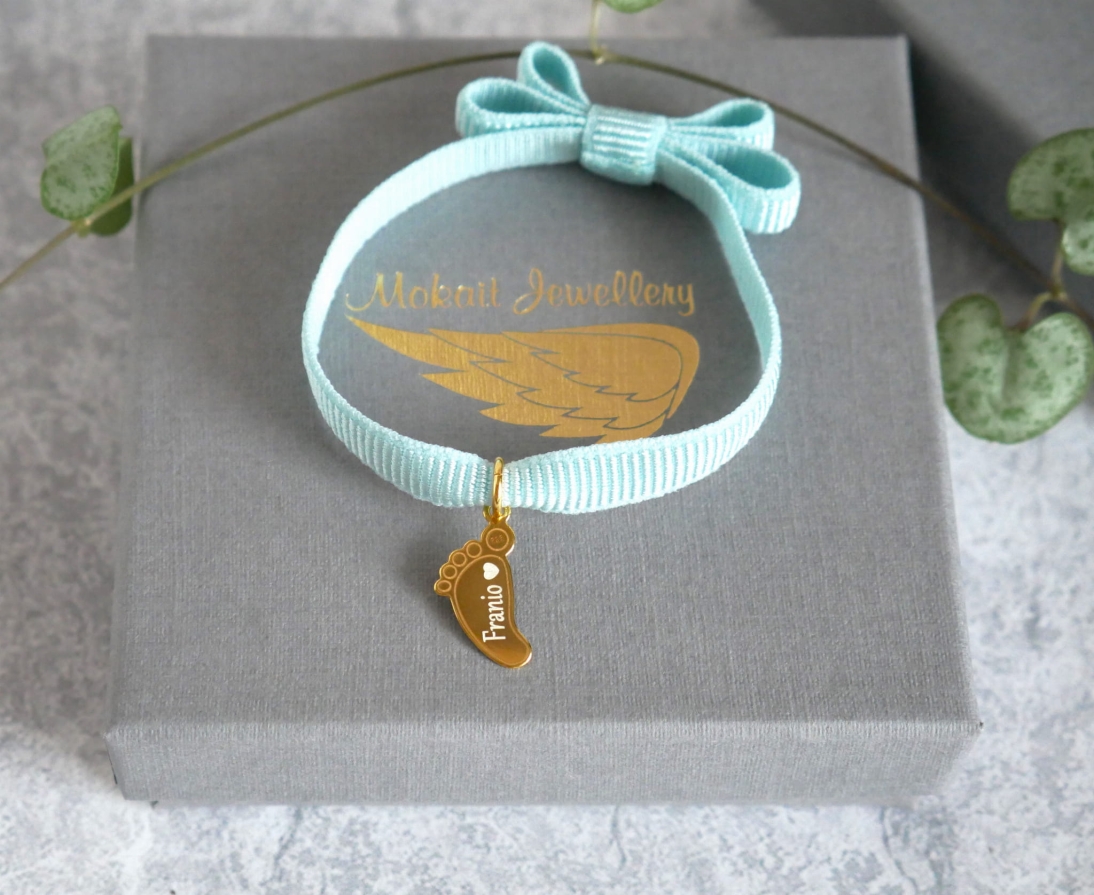 Bransoletka z kokardką na niebieskiej (Baby blue) elastycznej wstążce ze stópką dziecka z imieniem - Dowolna personalizacja - Bransoletka z kokardką  - Niebieska bransoletka kokardkowa na elastycznej wstążce ze stópką dziecka z imieniem - Dowolna personalizacja - Bransoletka z kokardką