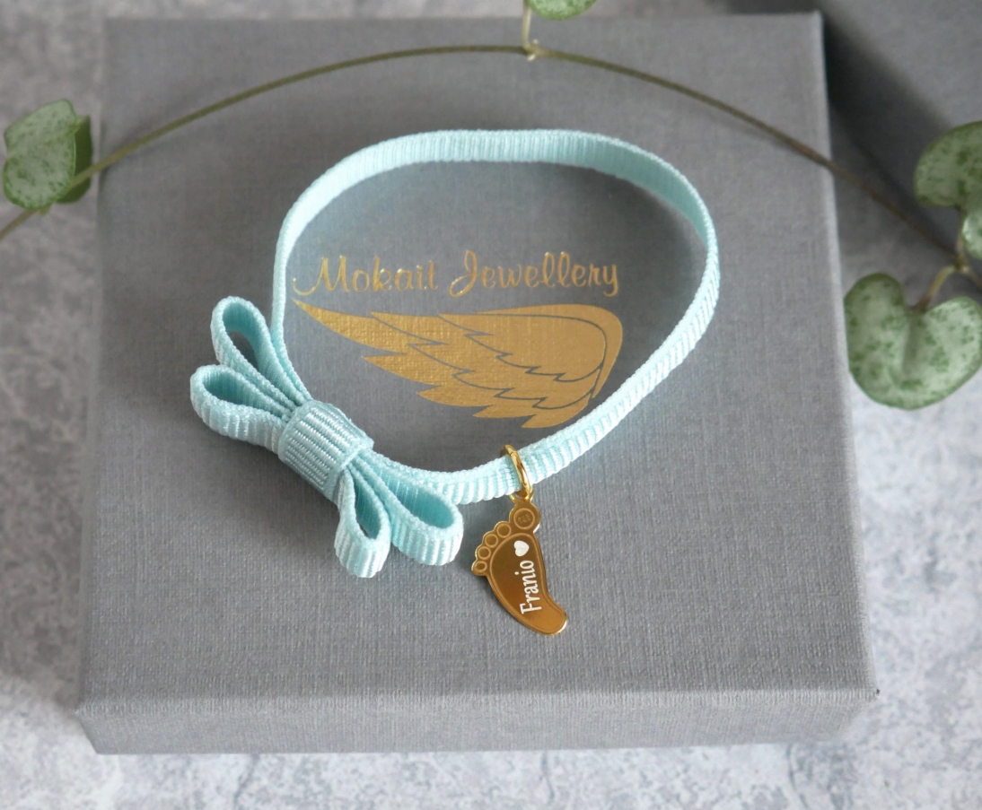 Bransoletka z kokardką na niebieskiej (Baby blue) elastycznej wstążce ze stópką dziecka z imieniem - Dowolna personalizacja - Bransoletka z kokardką  - Niebieska bransoletka kokardkowa na elastycznej wstążce ze stópką dziecka z imieniem - Dowolna personalizacja - Bransoletka z kokardką